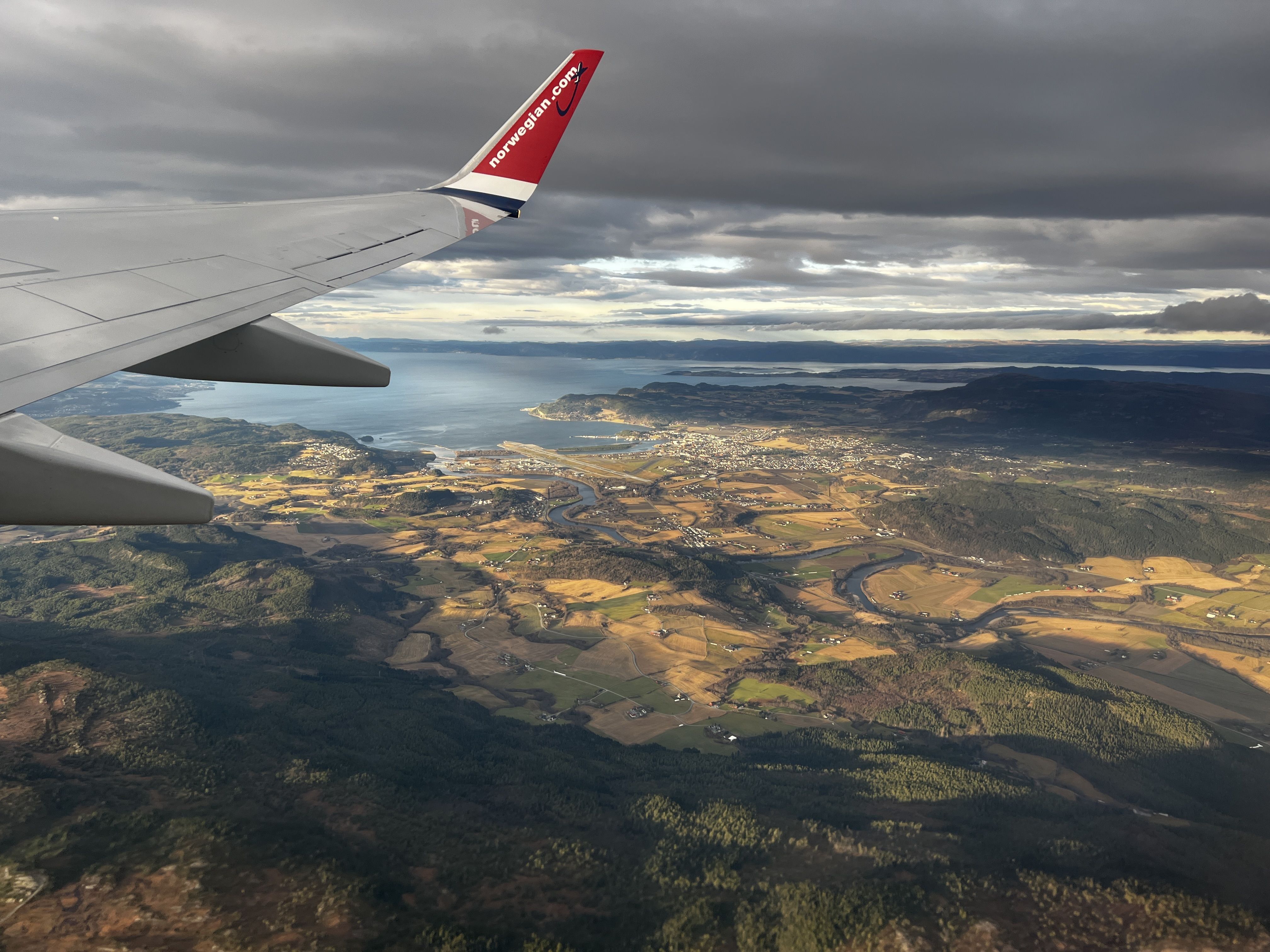View outside of a plane window overlooking forests and hills
