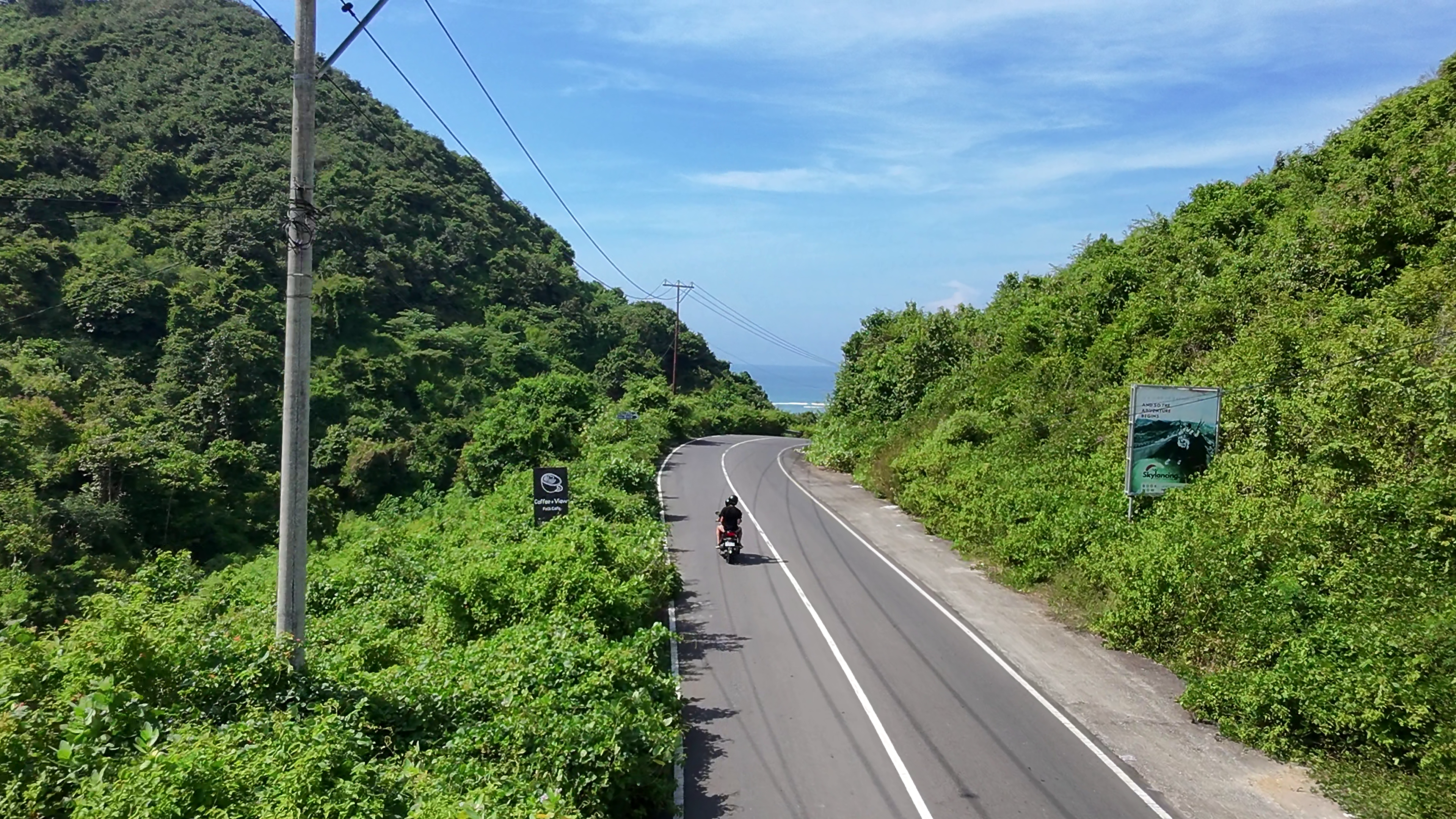 Arial footage of a motorcycle driving down the coast
