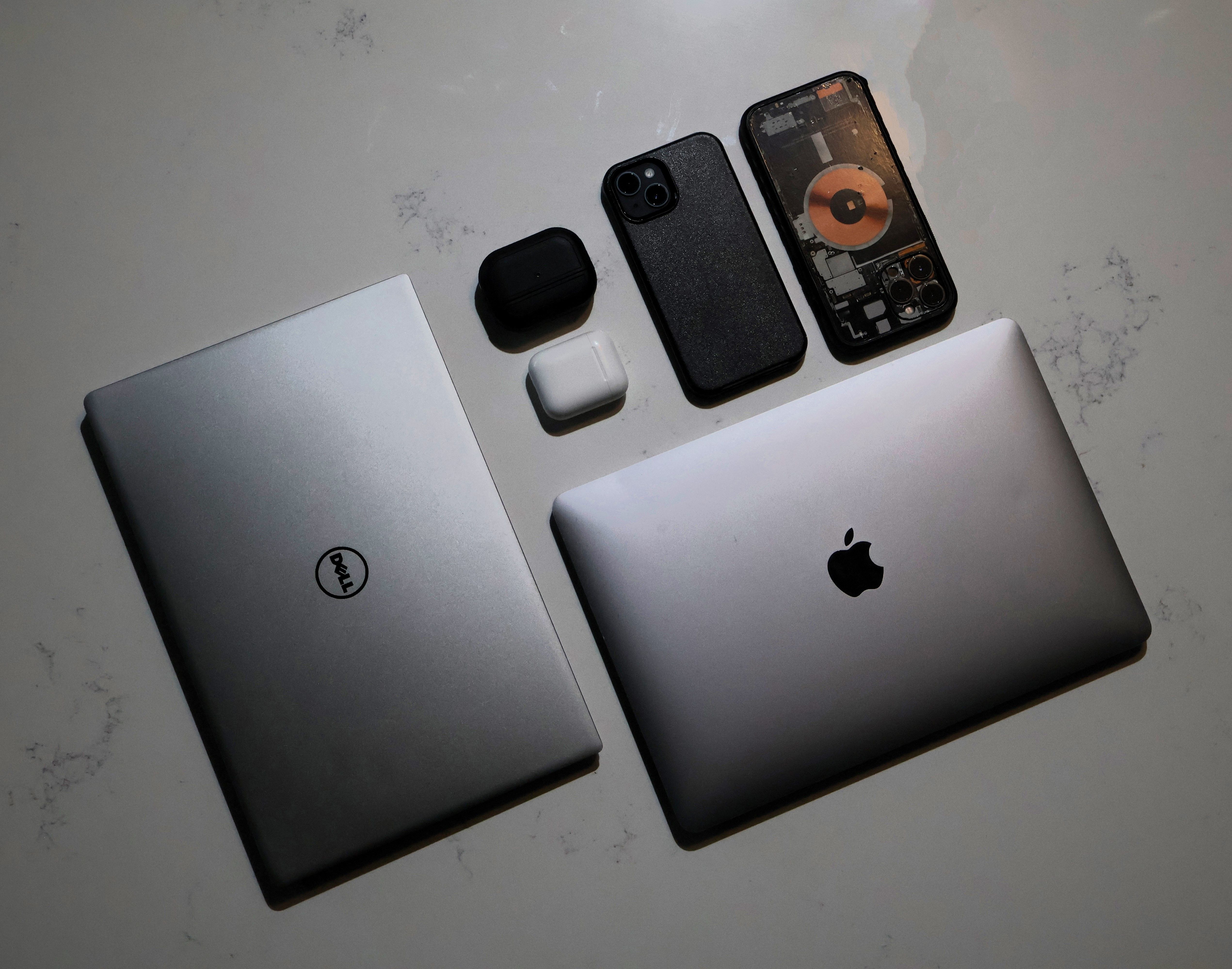 A collection of computers and phones on a table.